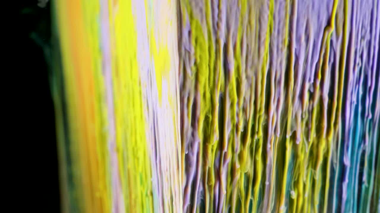 pintura de tinta multicolor fluye lentamente desde el cubo bajo el agua