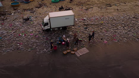 Aerial,-villagers-walking-on-extremely-polluted-beach-full-of-trash-in-Vietnam