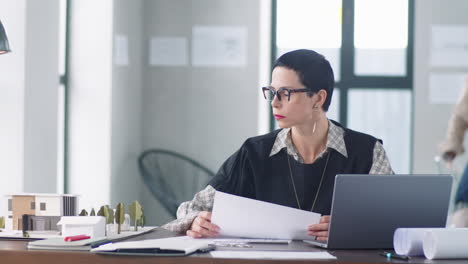 female architect reading documents in office