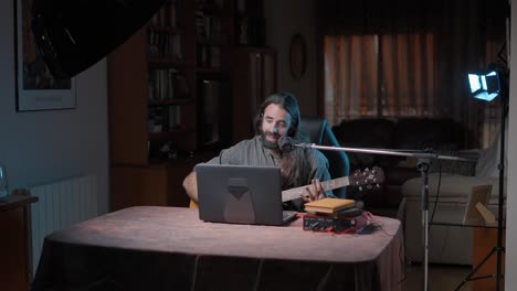 musician recording acoustic guitar at home