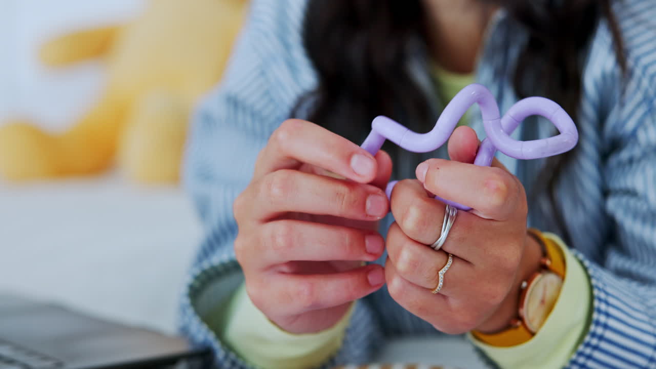 A woman plays with a purple fidget toy
