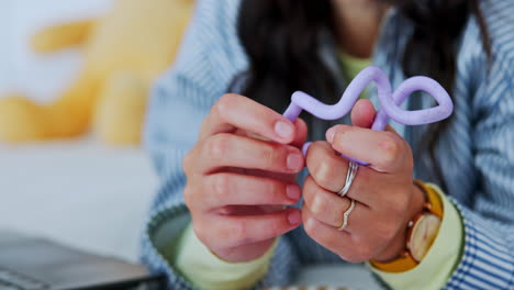 a woman plays with a purple fidget toy
