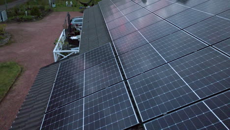 aerial: sunset mirroring from sunlight collectors on a solar powered house roof