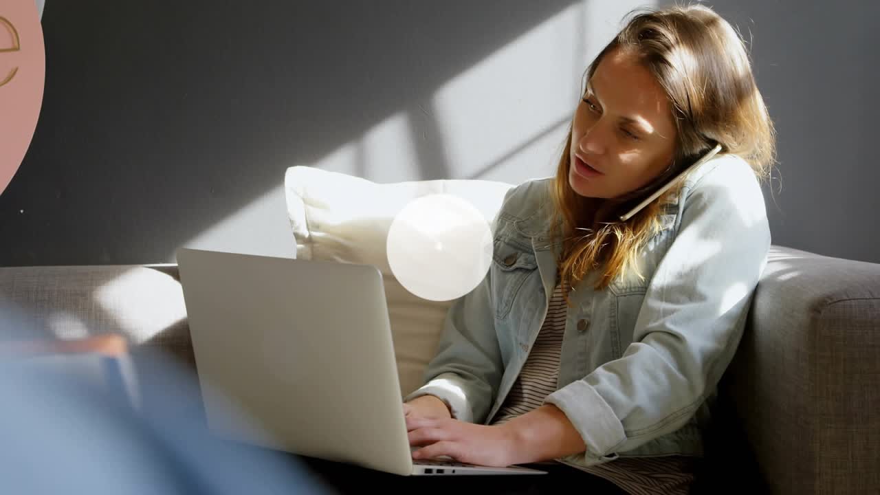 Mid-adult woman working remote, typing while holding phone, causing Wi-Fi nodes linking into web