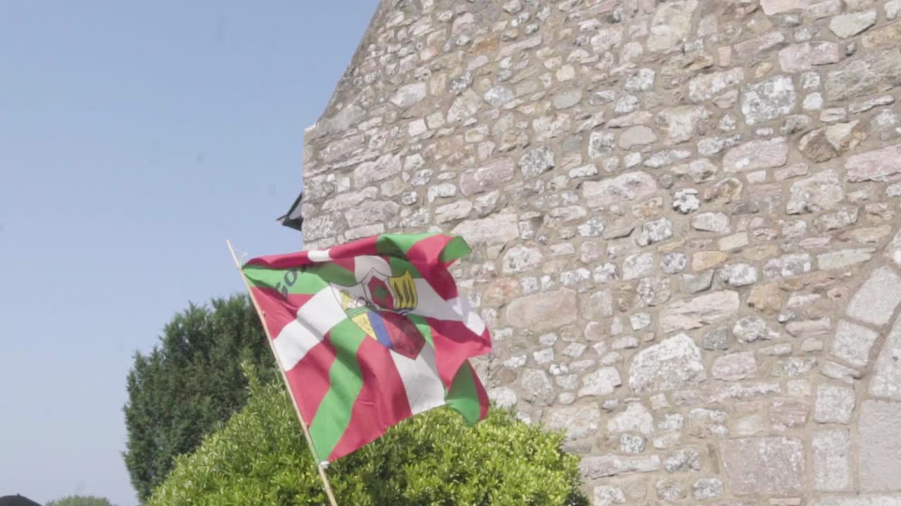 баскский флаг в замедленной съемке на фоне церкви