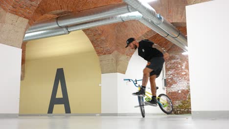 Mann-Auf-Einem-BMX-Fahrrad,-Der-Drinnen-Fährt-Und-Einige-Tricks-Macht