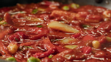 close-up of tomato sauce with vegetables cooking in a pan