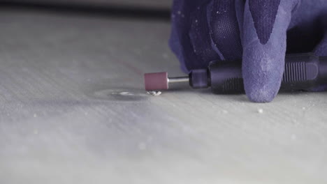 electric milling cutter with a sandpaper tip flattens a screw into the wood slow-motion