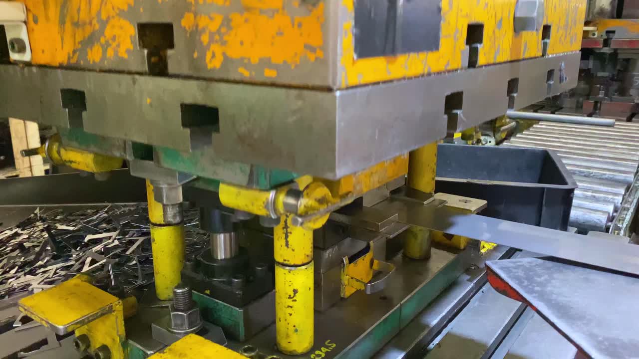 Mano de hombre colocando una placa de chapa de hierro en la máquina de prensa hidráulica - Proceso industrial de fabricación