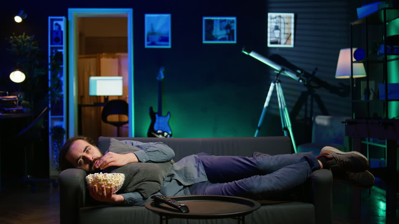 슬픈 사람이 누워, 우울증을 고, 기분이 좋아지기 위해 tv를 보고 있습니다.