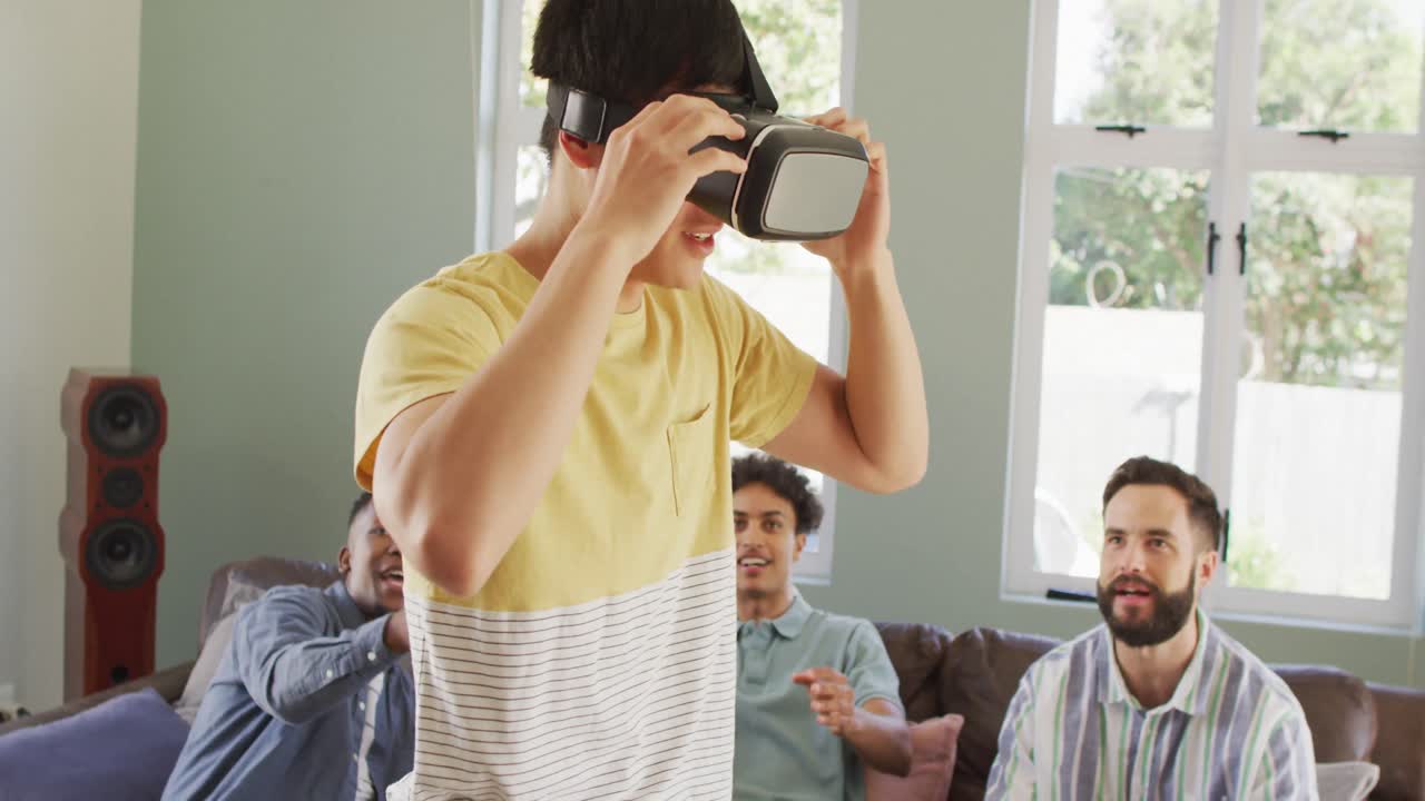 felices amigos varones diversos usando auriculares vr y hablando en la sala de estar