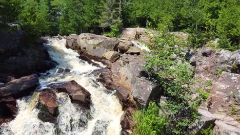 Drohnenaufnahmen-Eines-Fluges-über-Die-Wasserfälle-Eines-Flusses,-Der-Durch-Den-Wald-Fließt