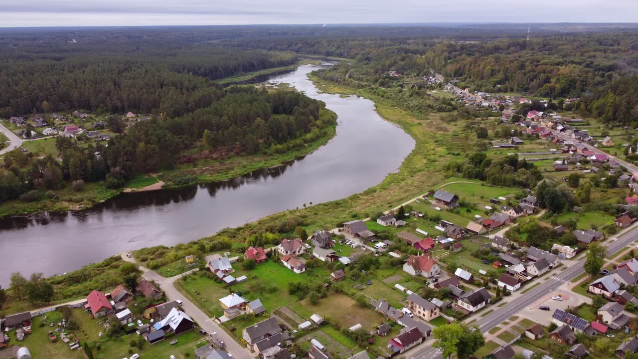 Aerial view of River Daugava in Kraslava with residential homes and surrounding forest