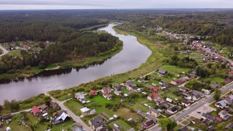aerial view of river daugava in kraslava with residential homes and surrounding forest