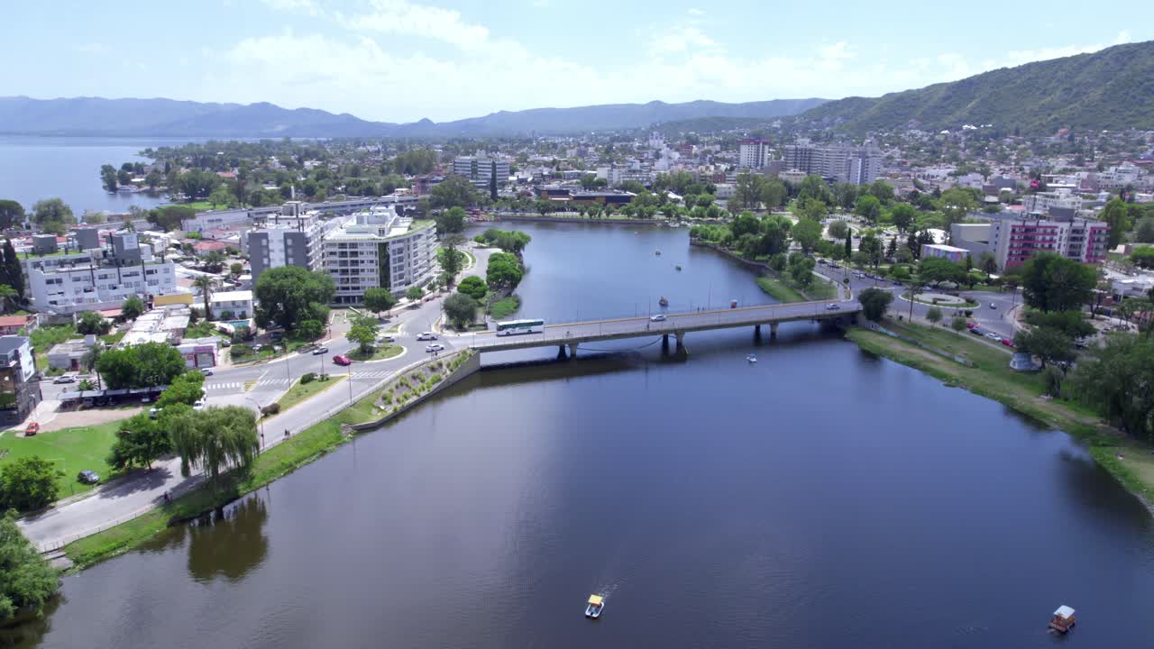 Aerial view of waterfront bridge with vehicles crossing over lake. Carlos Paz, Argentina