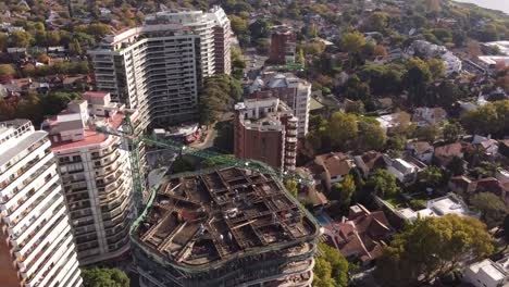 trabajo en progreso en el sitio de construcción con grúa en la parte superior del edificio en buenos aires en argentina, paisaje urbano en segundo plano