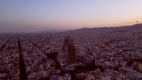 Drohnenaufnahmen-Aus-Der-Luft-Bei-Sonnenuntergang-Der-Stadtlandschaft-Von-Barcelona-Mit-Dem-Berühmten-Turm-La-Sagrada-Familia