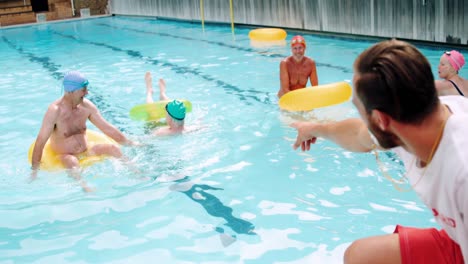 Swim-trainer-assisting-seniors-in-swimming