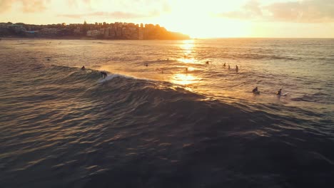 Luftaufnahme-Eines-Surfers-Am-Bondi-Beach-Bei-Sonnenaufgang,-Der-Eine-Welle-Fängt