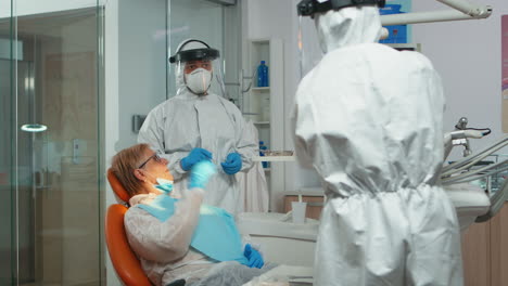 médico con máscara protectora haciendo limpieza higiénica de los dientes