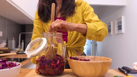 woman preparing fermented red cabbage