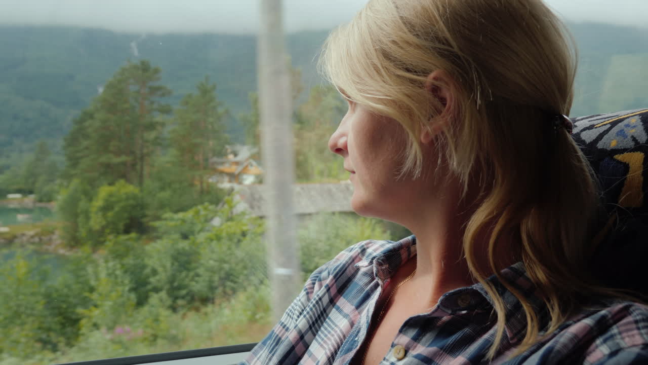 A Woman Travels By Bus In Norway Looks Out The Window At The Beautiful Fjords