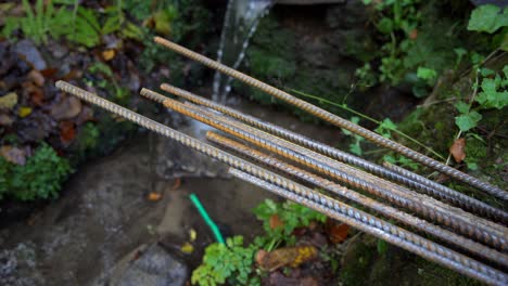 cerca de la barra de refuerzo oxidada, agua cayendo en el fondo