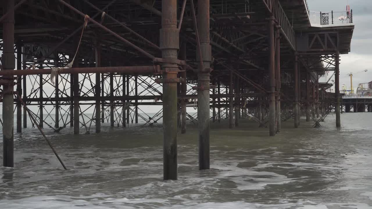 basement of famous brighton pier in england uk. metal pillars and small waves
