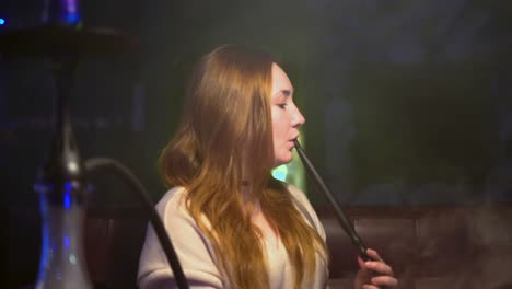 woman smoking hookah in night club