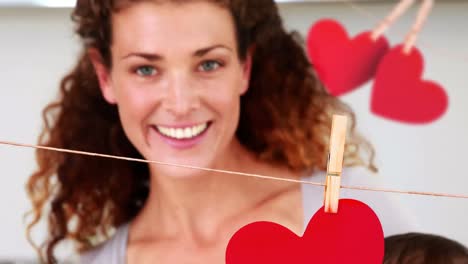 animación de corazones cayendo sobre madre caucásica con su bebé