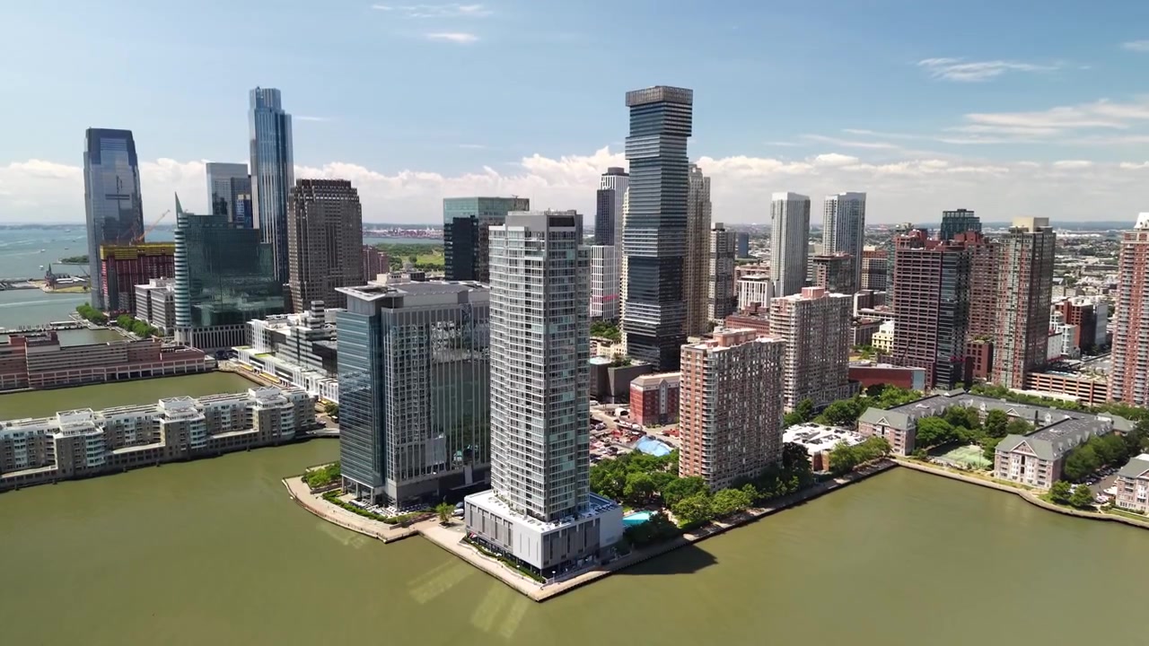 Vista aérea espetacular do horizonte de Jersey City, apresentando arranha-céus modernos e edifícios residenciais ao longo da orla do rio Hudson em um dia claro e ensolarado com céus azuis