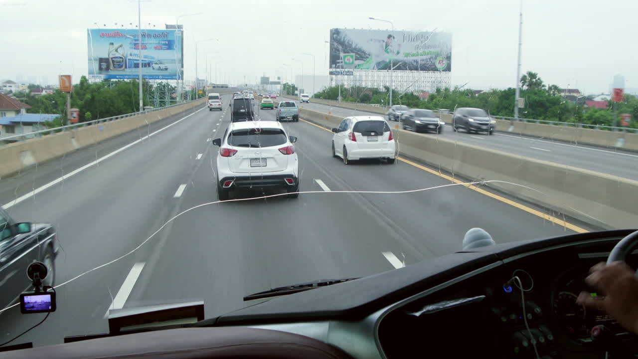 Driving on a Rainy Highway in City Traffic