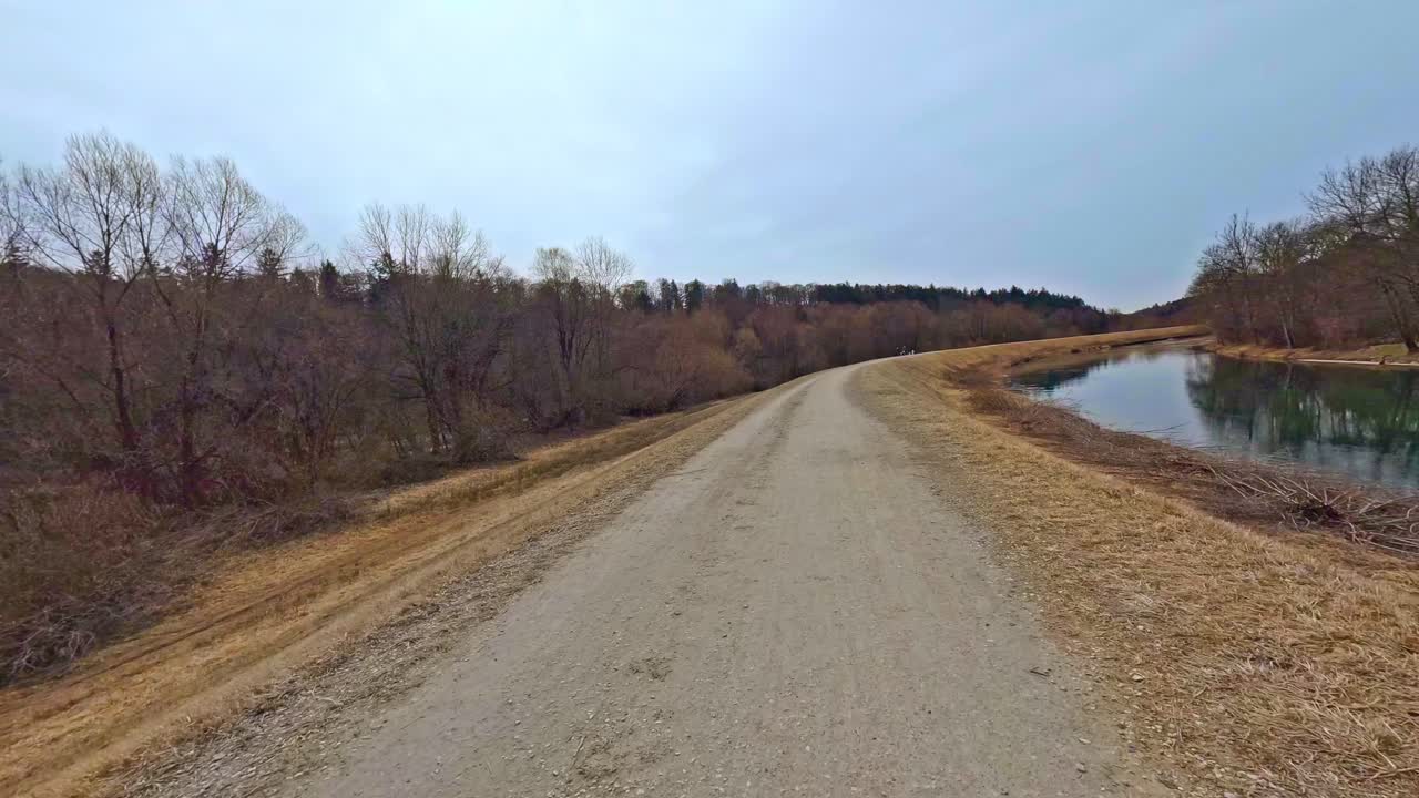 montando una bicicleta rápida en un hermoso paisaje al lado de un río que fluye bajo el cielo azul