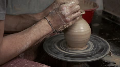 the potter makes a jug of clay. ceramist. a man makes a vase on a potter's wheel