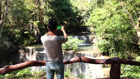 the man using smartphone selfie at waterfall