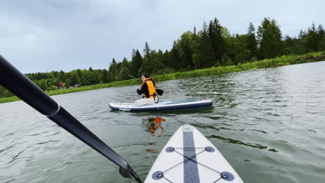 una mujer haciendo paddleboard en un lago.