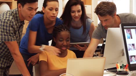 Business executives discussing over laptop