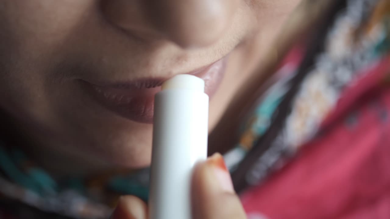 mujer aplicar bálsamo labial