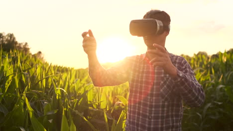 the farmer of the future uses of vr glasses to control corn plantations and quality control of plants and soil analysis for irrigation and fertilizer plants standing in a field at sunset lens flare