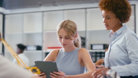 female teacher with female high school student using digital tablet in stem class