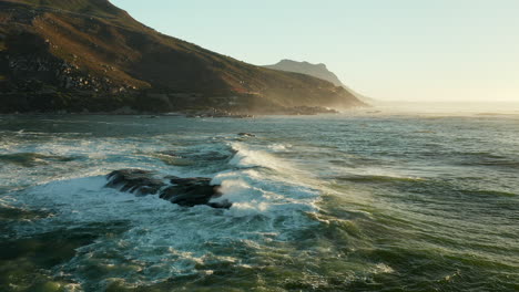 Schaumige-Wellen,-Die-Auf-Felsen-Am-Strand-Von-Oudekraal-In-Kapstadt,-Südafrika,-Spritzen