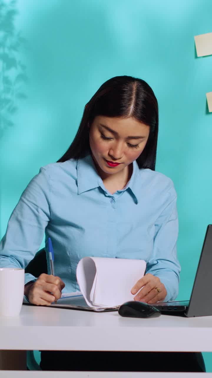 Office clerk cross-checking paperwork | Premium Stock Video Footage