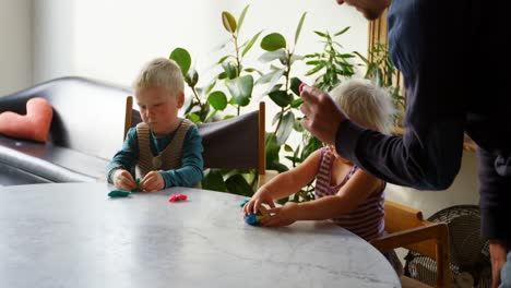 father and children playing together with clay in a comfortable home 4k