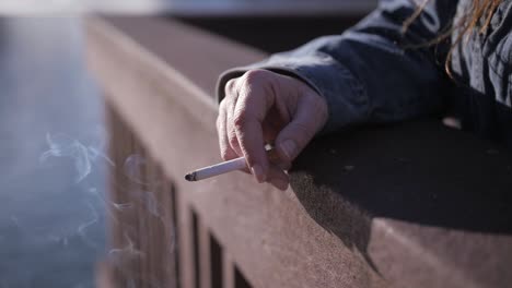 cigarette smoldering in woman's hand