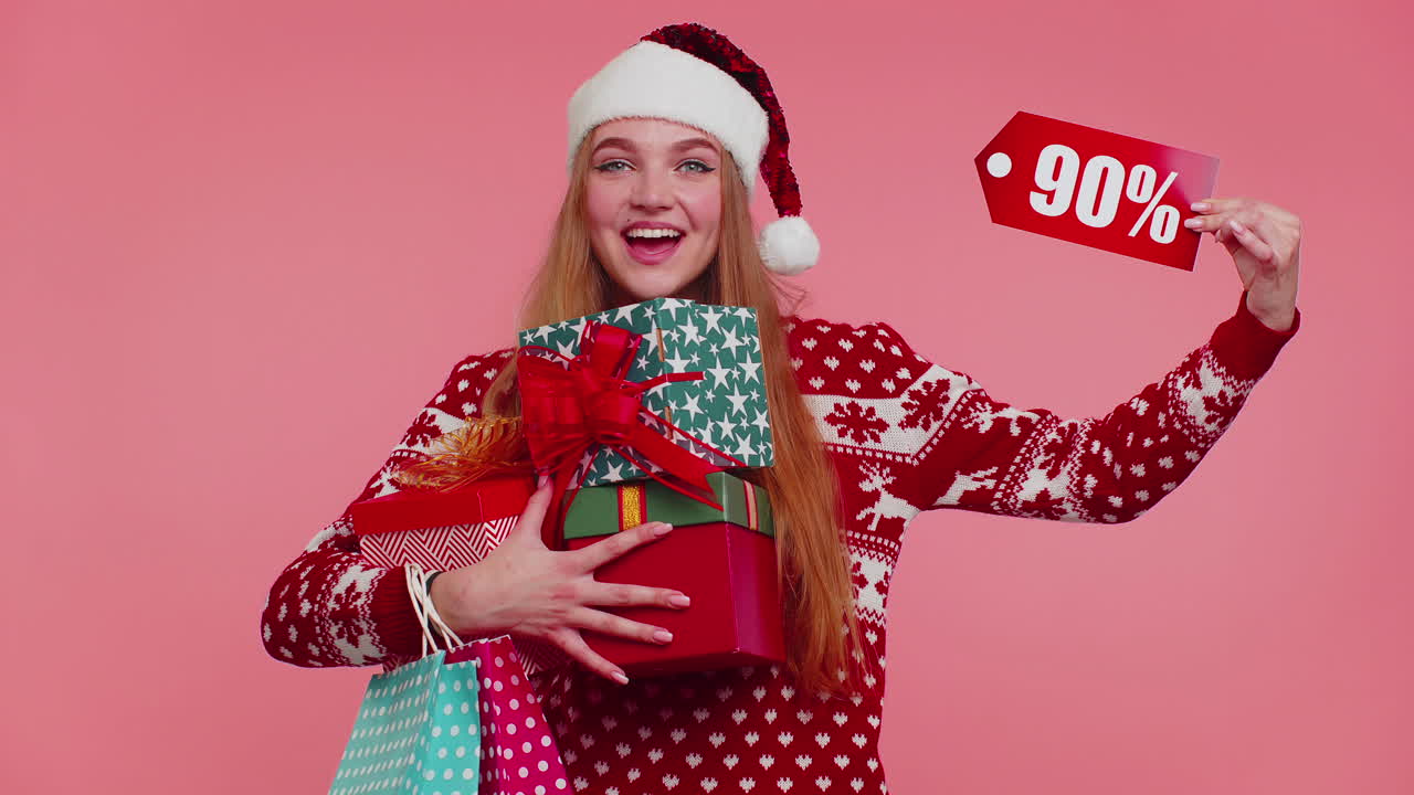 mujer con suéter de navidad mostrando caja de regalos y inscripciones de descuento del 90 por ciento nota de texto de banner