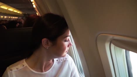 young girl in the plane looks through the window