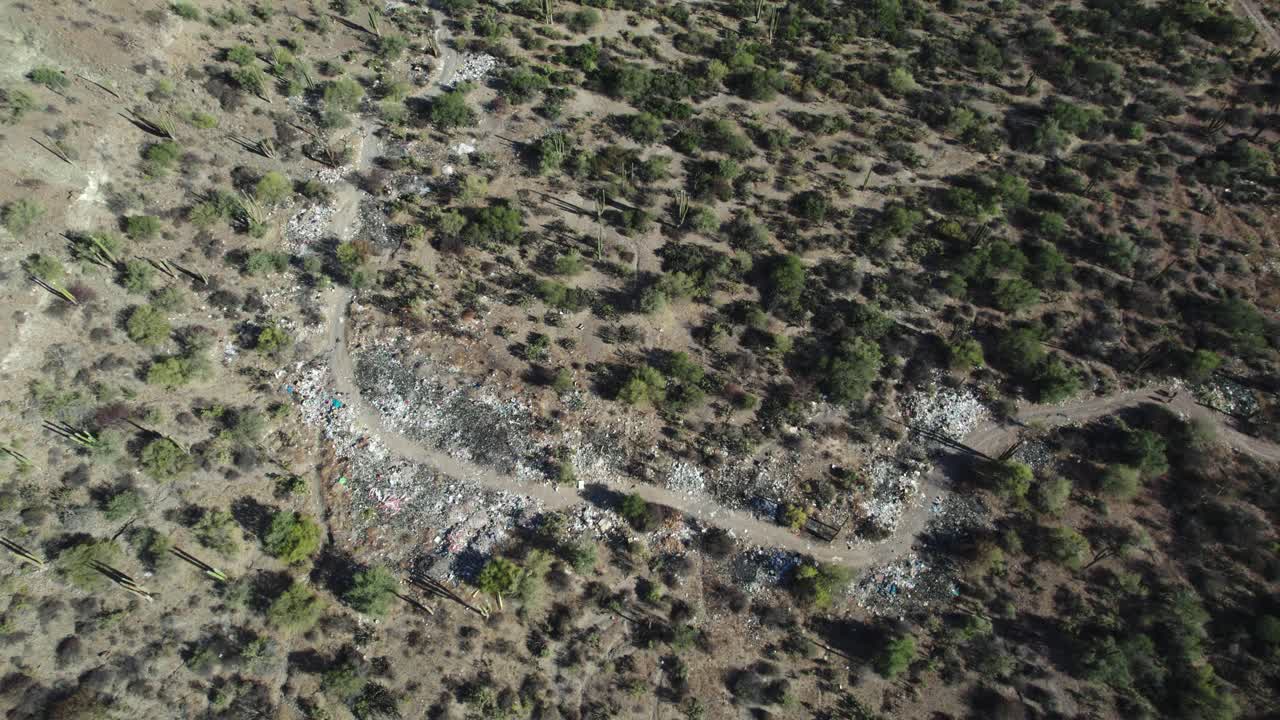 una vista de la basura empañando el paisaje desértico de mulege, baja california sur, méxico - avión no tripulado volando hacia adelante