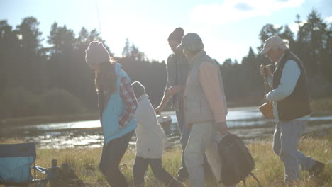 multi generation family arriving at tent in countryside