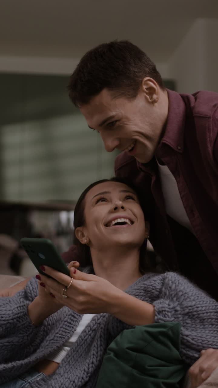 Happy Couple Using Smartphone at Home