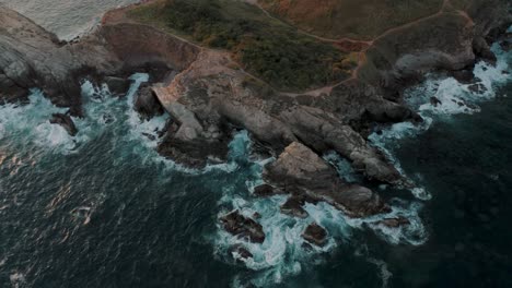 bird's eye view of waves crashing the cliff on the mazunte beach in oaxaca, mexico